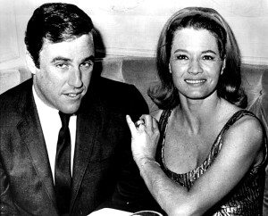 Burt Bacharach and Angie Dickinson share a paparazzi moment at a Hollywood nightclub circa 1966, when they fell in love. Bacharach was the composer of 1960s pop hits like “Say A Little Prayer” and “The Look of Love.” Dickinson was a movie actress with legs famously insured for a million dollars. He wears a suit and tie and glances down in a chuckle. She wears a low-cut cocktail dress and turns to smile directly at the camera.